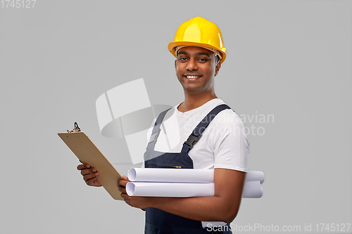 Image of happy indian builder with blueprint and clipboard