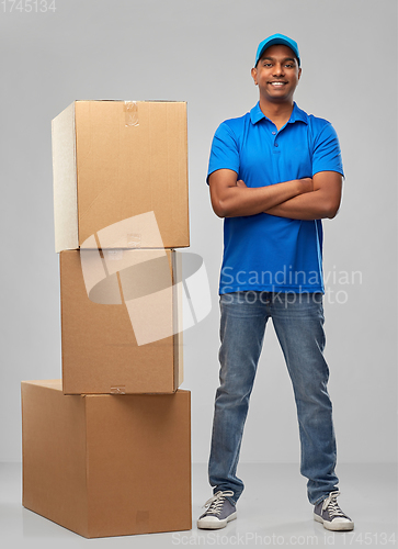 Image of happy indian delivery man with parcel boxes
