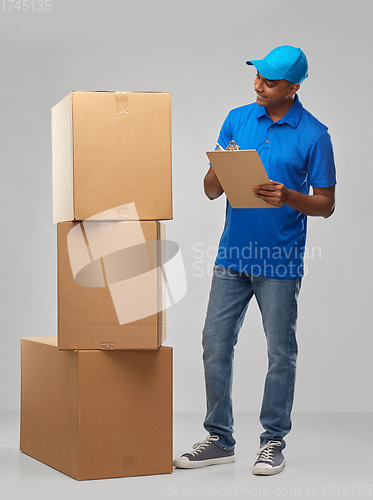 Image of indian delivery man with boxes and clipboard