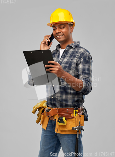 Image of indian builder in helmet calling on smartphone