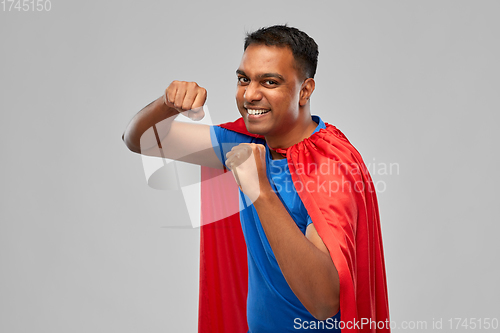 Image of indian man in superhero cape makes winning gesture