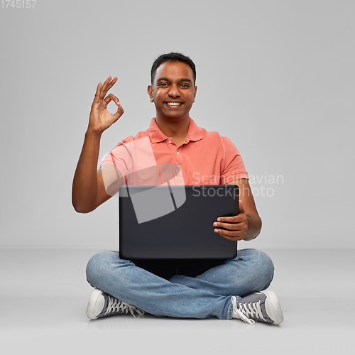 Image of happy indian man with laptop computer showing ok