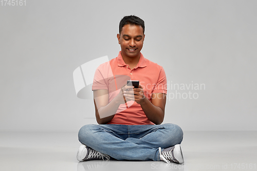 Image of happy indian man using smartphone