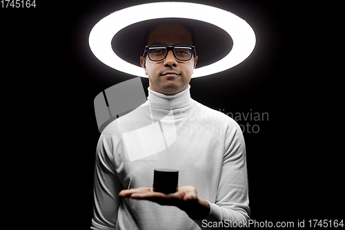 Image of man in glasses with smart speaker under lamp