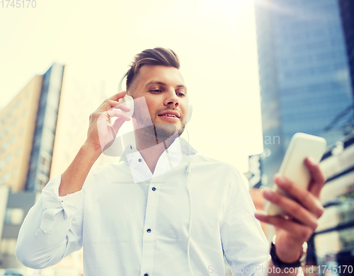 Image of man with headphones and smartphone listening music