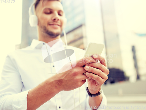 Image of man with smartphone and headphones listening music