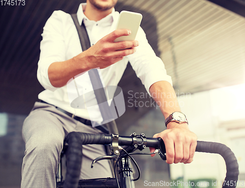 Image of man with smartphone and fixed gear bike on street