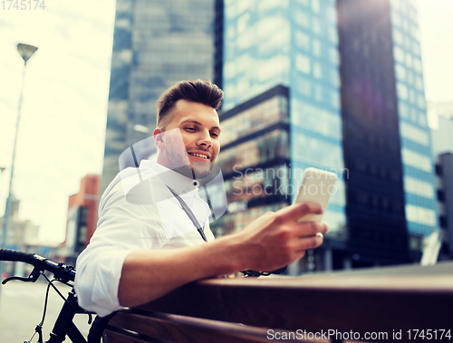 Image of happy man with smartphone and bicycle in city