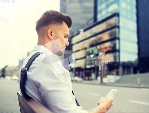 Image of man with smartphone and bicycle in city