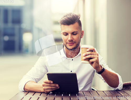 Image of man with tablet pc and coffee at city cafe