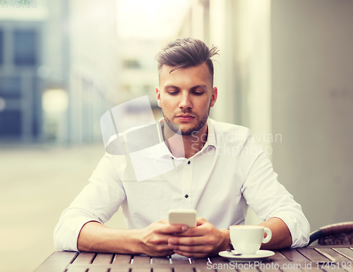 Image of man with smartphone and coffee at city cafe