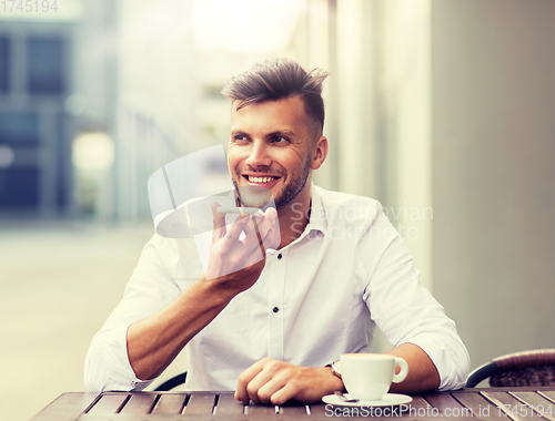 Image of man with coffee and smartphone at city cafe