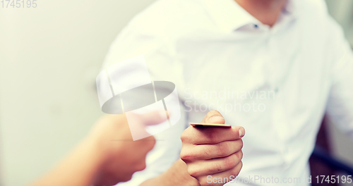 Image of close up of man giving credit card to waiter