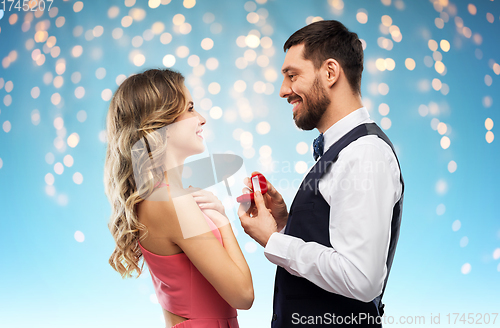 Image of man giving woman engagement ring on valentines day