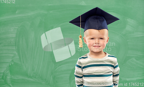 Image of little boy in mortar board over green chalkboard