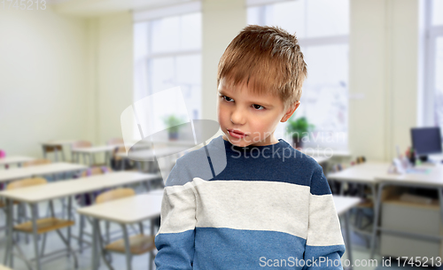 Image of portrait of gloomy little boy at school