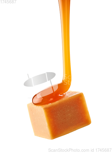 Image of caramel sauce flowing on flying caramel candy