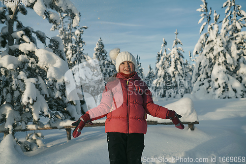 Image of girl throwing fresh snow at beautiful sunny winter day