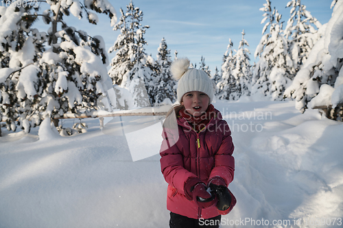 Image of girl throwing fresh snow at beautiful sunny winter day