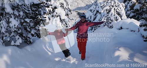 Image of mother and daughter walking at beautiful sunny winter day