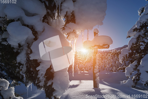 Image of wooden cross covered with fresh snow at beautiful fresh winter morning