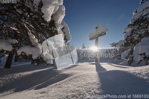 Image of wooden cross covered with fresh snow at beautiful fresh winter morning