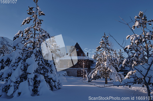 Image of wooden cabin with fresh snow on cold winter morning