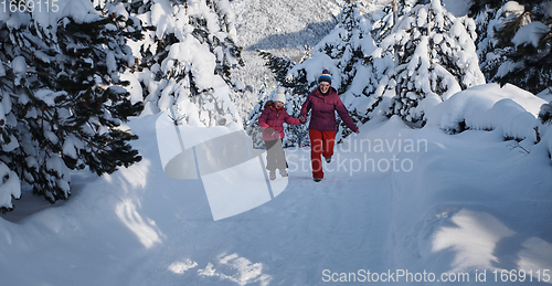 Image of mother and daughter walking at beautiful sunny winter day