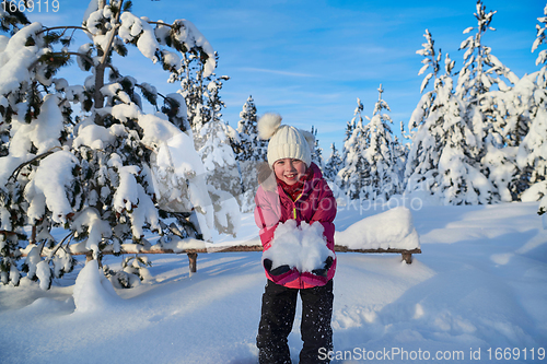 Image of girl throwing fresh snow at beautiful sunny winter day