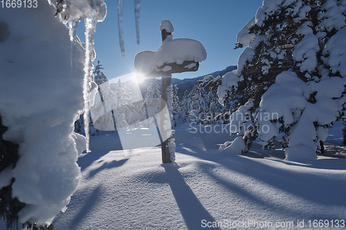 Image of wooden cross covered with fresh snow at beautiful fresh winter morning