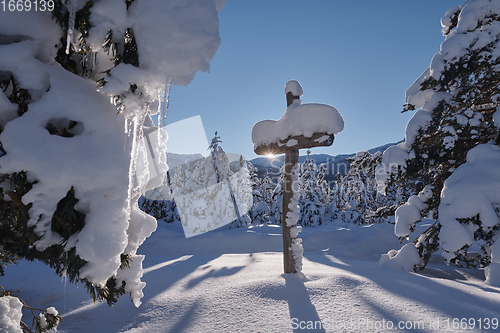 Image of wooden cross covered with fresh snow at beautiful fresh winter morning