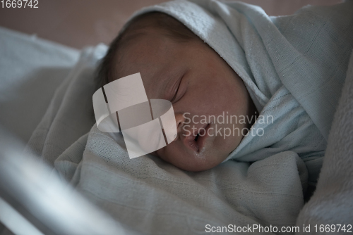 Image of newborn baby sleeping in bed at hospital