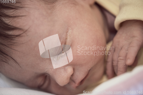 Image of newborn baby sleeping in bed at hospital