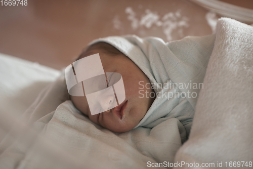 Image of newborn baby sleeping in bed at hospital