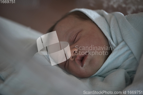 Image of newborn baby sleeping in bed at hospital