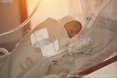 Image of newborn baby sleeping in bed at hospital