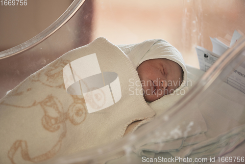 Image of newborn baby sleeping in bed at hospital