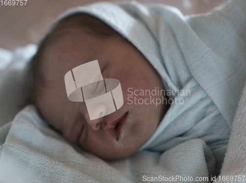 Image of newborn baby sleeping in bed at hospital