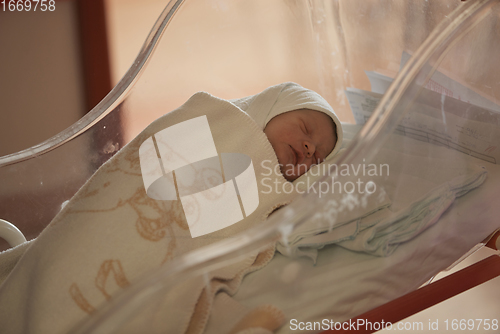 Image of newborn baby sleeping in bed at hospital