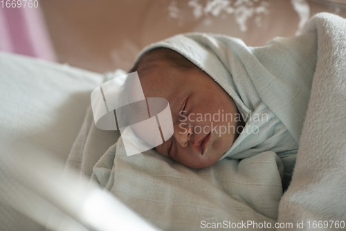 Image of newborn baby sleeping in bed at hospital