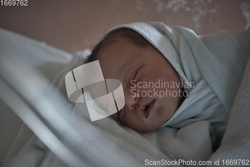 Image of newborn baby sleeping in bed at hospital