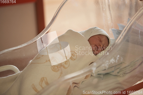 Image of newborn baby sleeping in bed at hospital