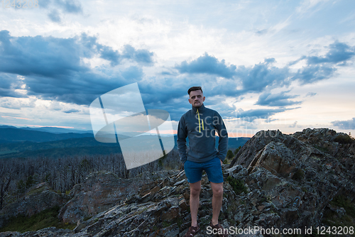 Image of Man standing on top of cliff