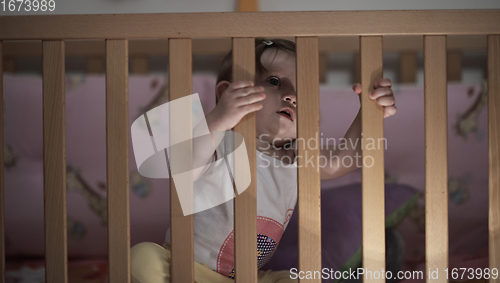 Image of cute little one year old baby and making first steps in bed