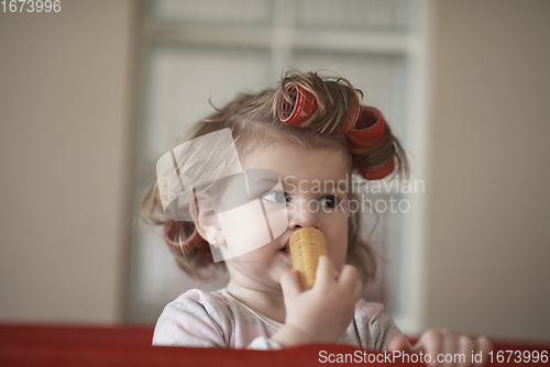 Image of little baby girl with strange hairstyle and curlers