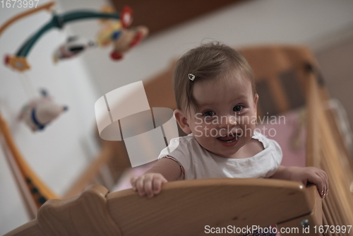 Image of cute little one year old baby and making first steps in bed