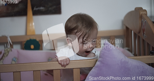 Image of cute little one year old baby and making first steps in bed