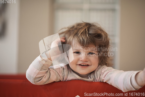 Image of little baby girl with strange hairstyle and curlers