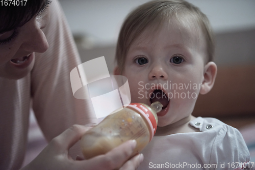 Image of little baby drinking juice from bottle