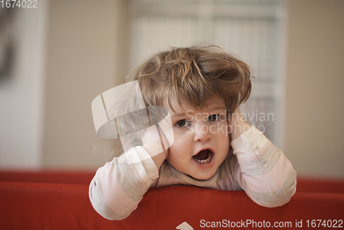 Image of little baby girl with strange hairstyle and curlers